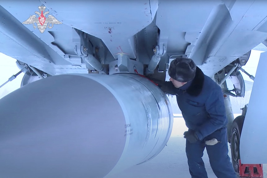 An airman checks a Russian Air Force MiG-31 fighter with a hypersonic missile.