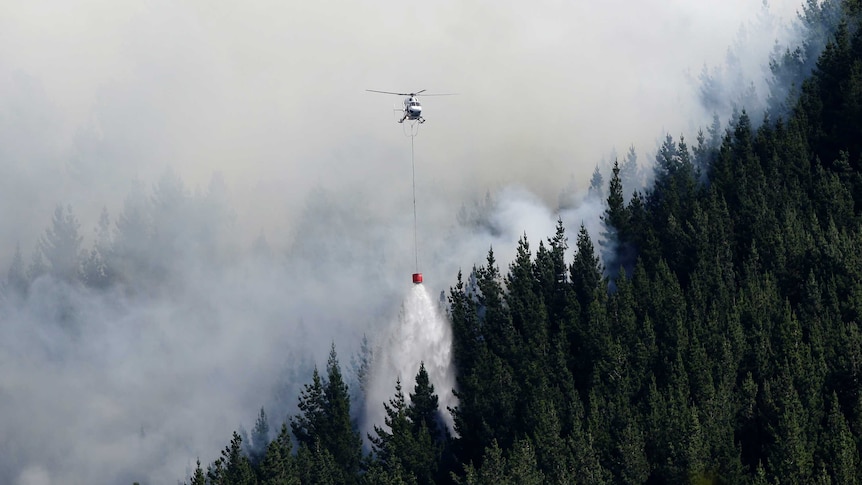 A helicopter dumps water on a fire in the Port Hills near Christchurch.