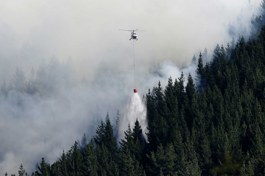 A helicopter dumps water on a fire in the Port Hills near Christchurch.