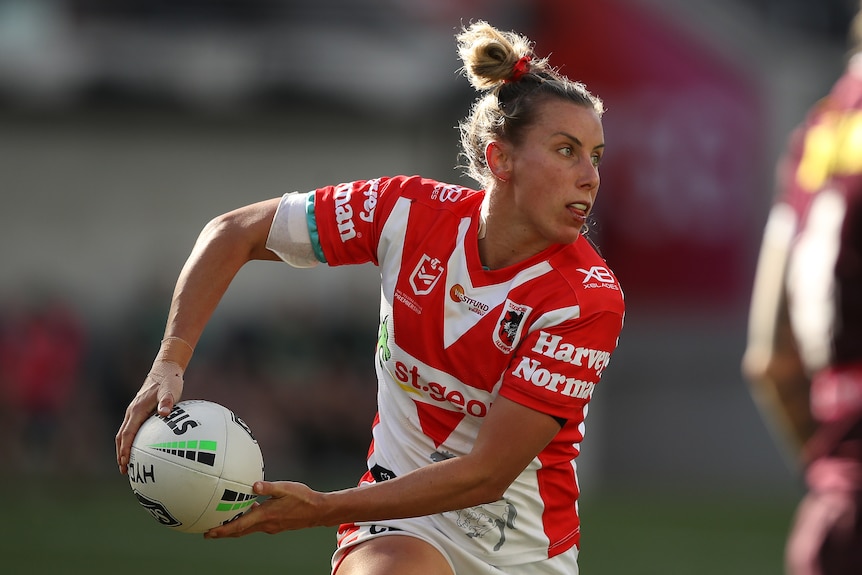 A woman looks to pass during an NRL match