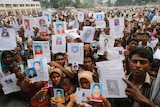 Relatives show pictures of missing Bangladesh workers