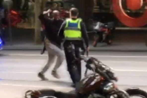 The Bourke Street attacker lunges with a knife at a police officer on Bourke Street.