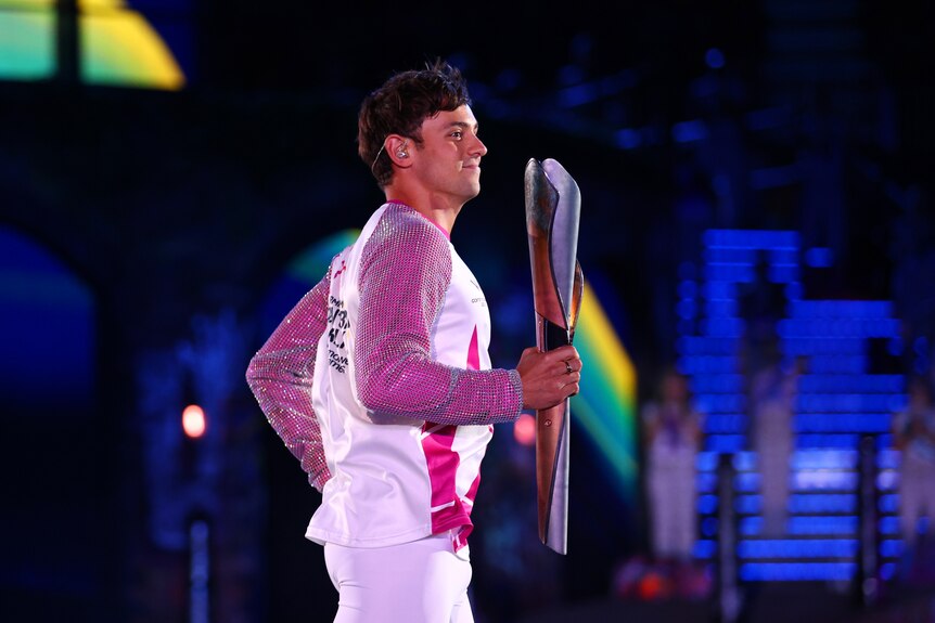 Tom Daley carries a silver baton