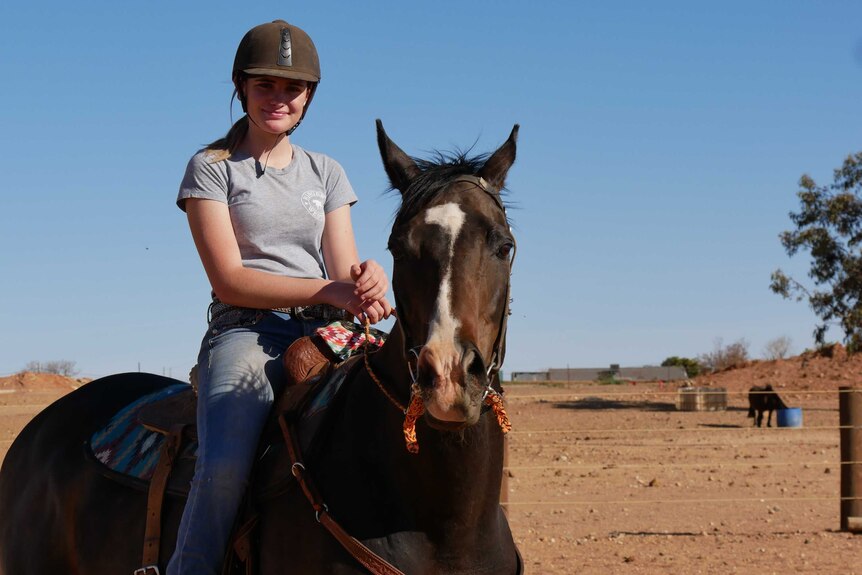 15 year old horse rider Grace Norley sits on her horse Sydney.