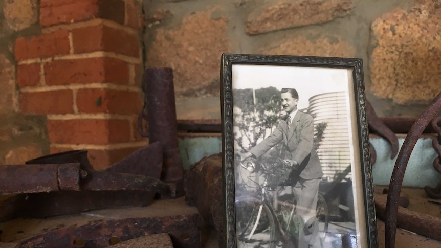 An old photo of world war 2 serviceman Lynn Parsons sits in a frame on a work bench.
