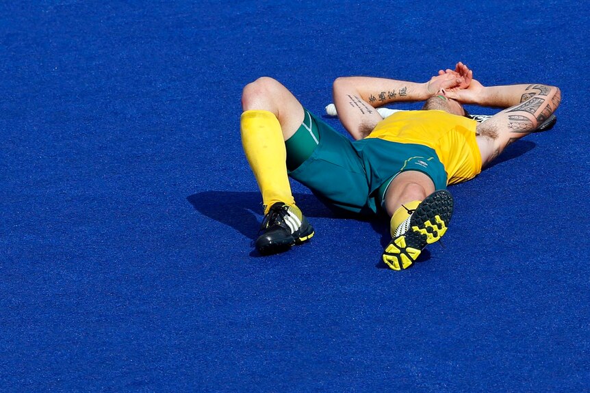 Kieran Govers lies on the pitch after Australia's loss to Germany in the men's Olympics semi-final.