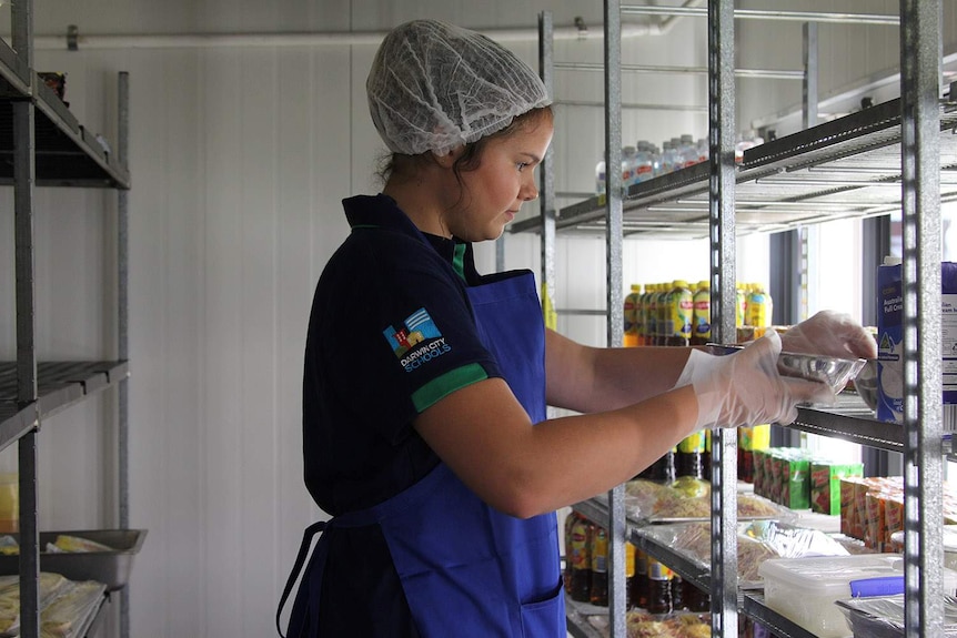 A young woman in a cooling fridge