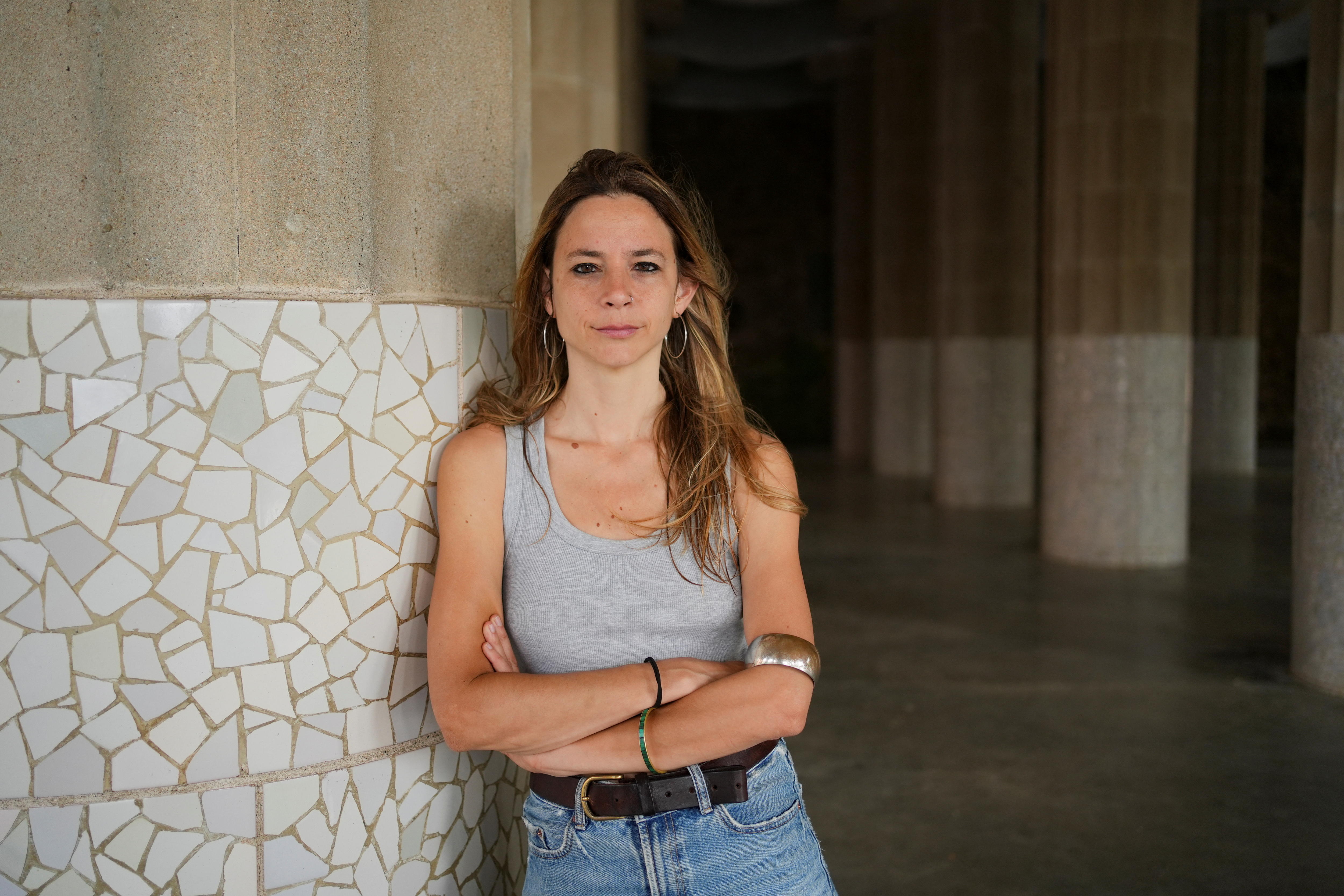 A woman leans against a wall.