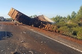 Debris from a road accident, a truck is crumpled by the side of the road.