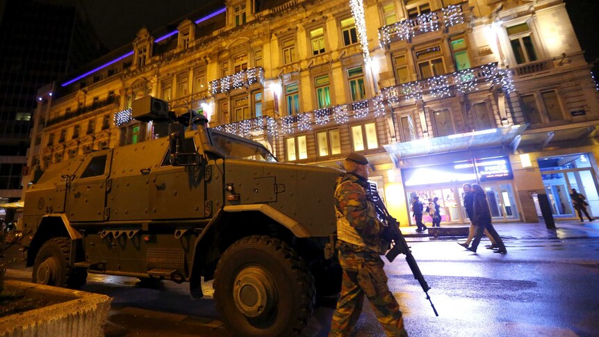 A Belgian soldier patrols near an armoured vehicle in central Brussels
