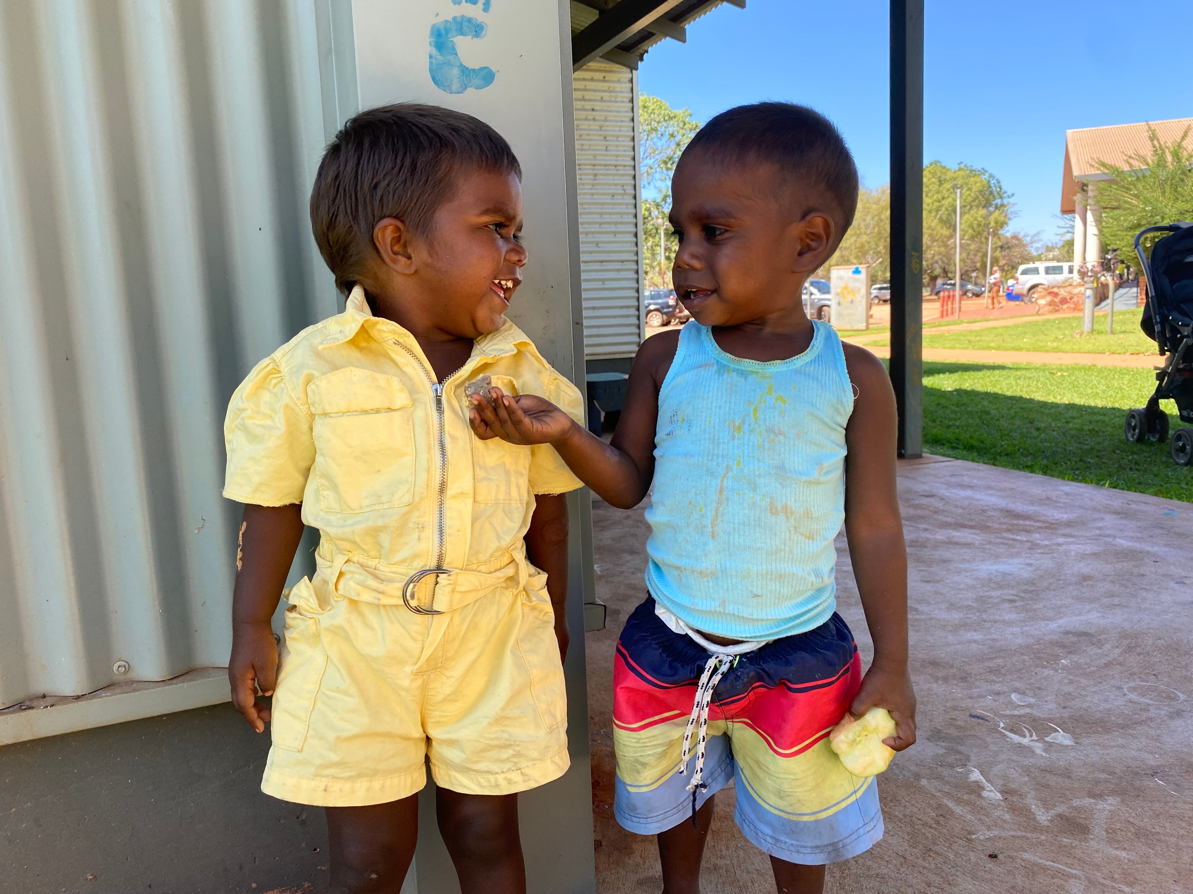 Two Aboriginal children smiling at each other