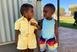Two Aboriginal children smiling at each other