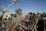 Palestinians look at Egyptian forces standing on their side of the border town of Rafah.