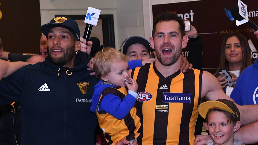 Josh Gibson and Luke Hodge and his children sing the Hawks club song.