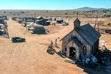 An aerial view of an empty Western film set depicting an old town and church