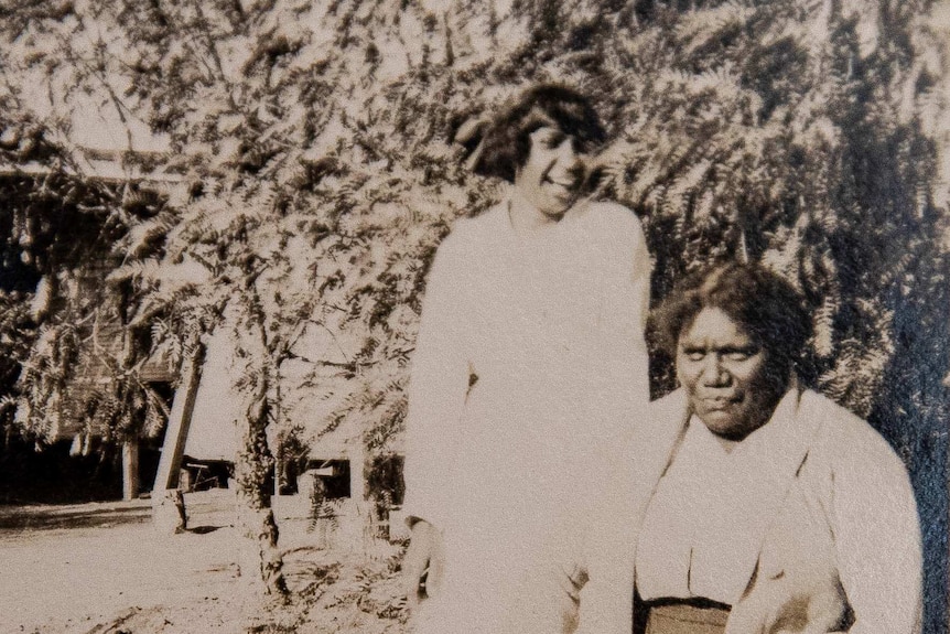 Maria Koosney (standing) and Angelina McKenzie in the gardens of "Whitehill" Station, Longreach in 1920.