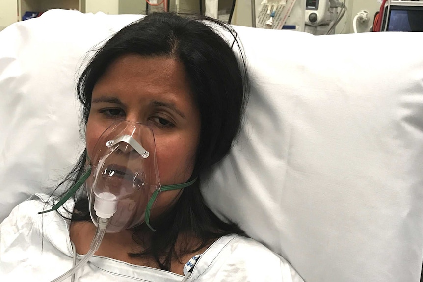 Dr Pooja Newman lays in a hospital bed.