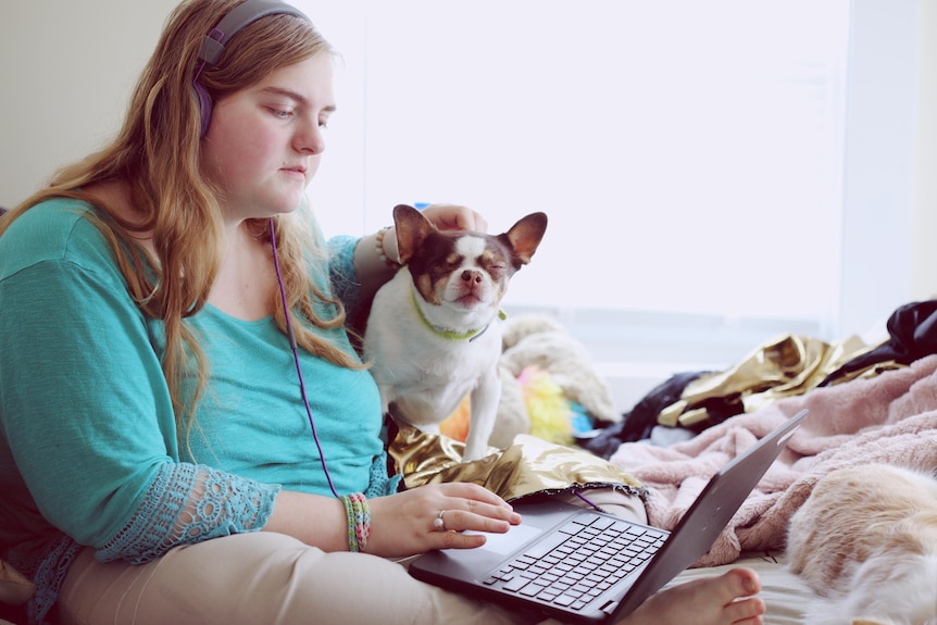 Young woman searching laptop and wears headphones