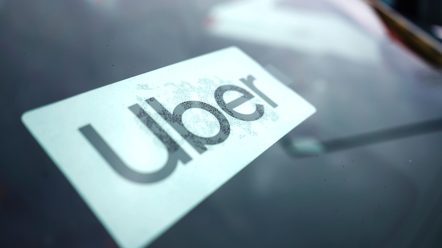 A close up of an Uber sign on a windscreen