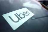 A close up of an Uber sign on a windscreen