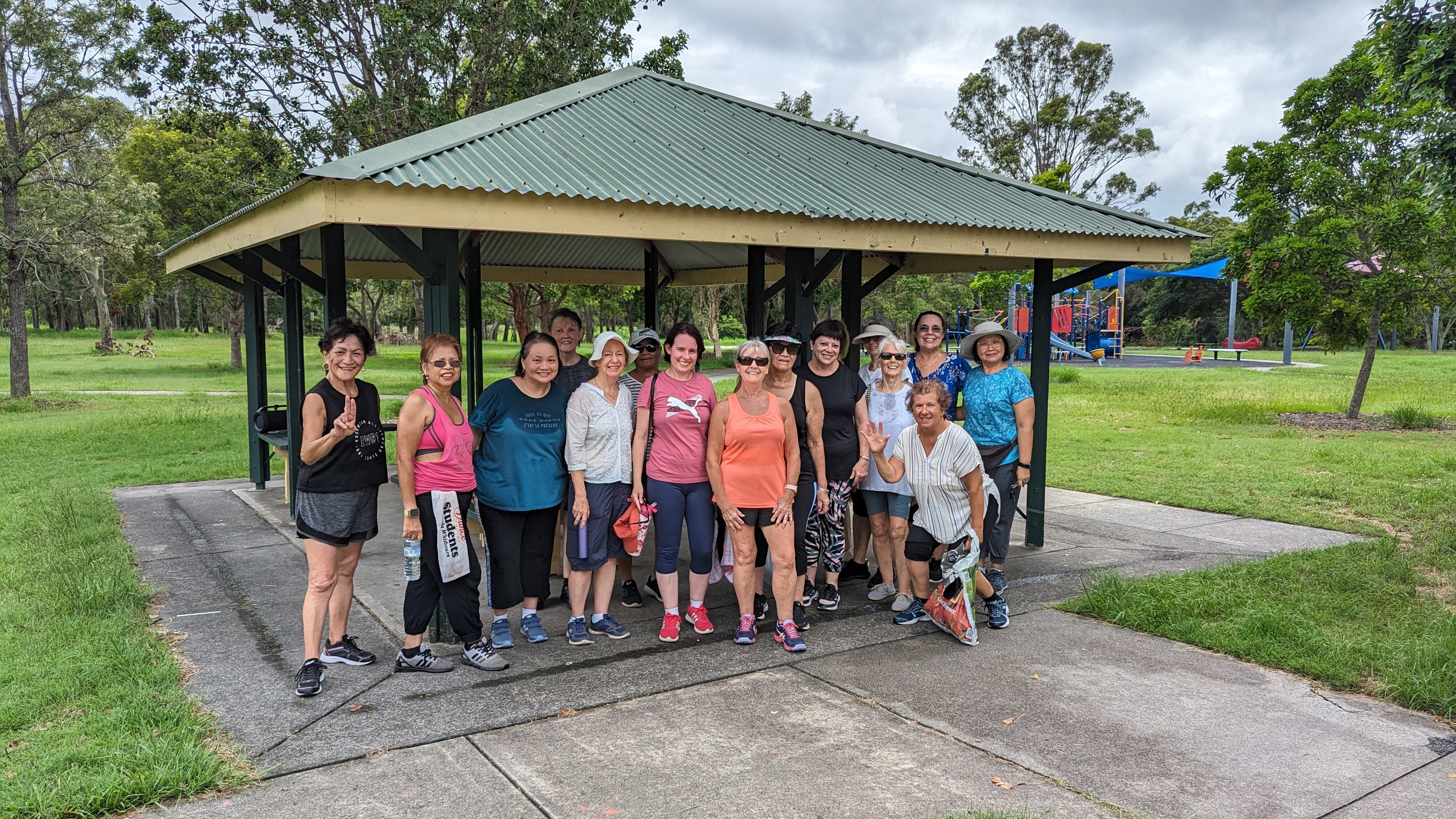 A group of women sweaty and smiling after an outdoor dance class