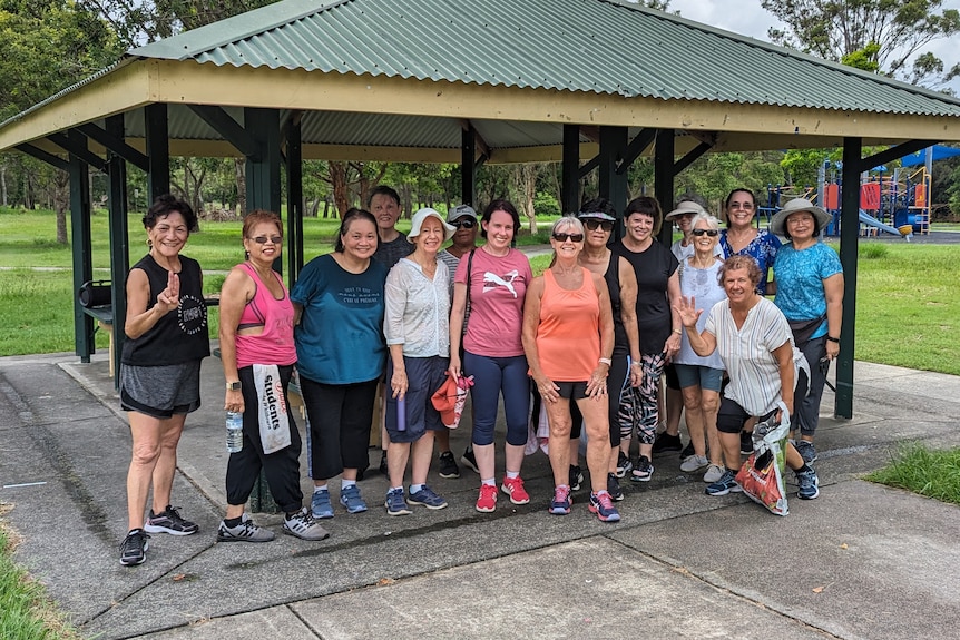 A group of women sweaty and smiling after an outdoor dance class