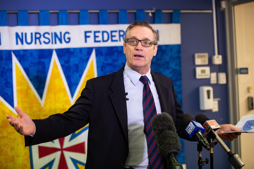 Australian Nursing Federation Secretary of State Mark Olsen gestures lively at a rostrum