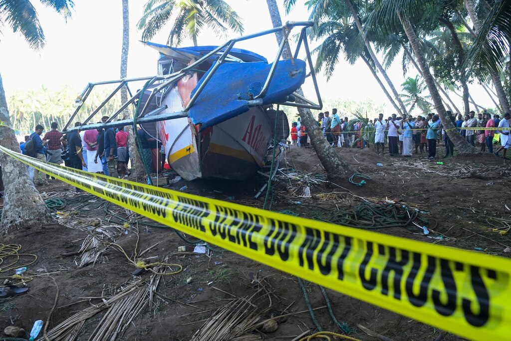 Many people gatherat People look at a tourist boat that capsized Sunday night in Malappuram, Kerala.