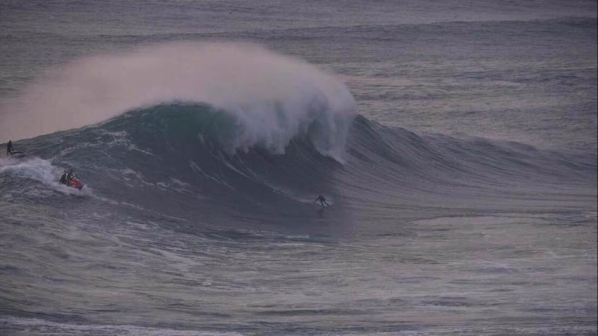 Brad Domke rides a giant wave at the big wave spot known as Nazare in Portugal
