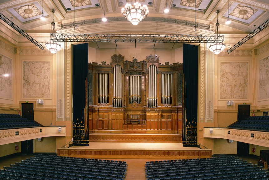 An ornate theatre with an almost floor to ceiling organ taking up the entire front wall.