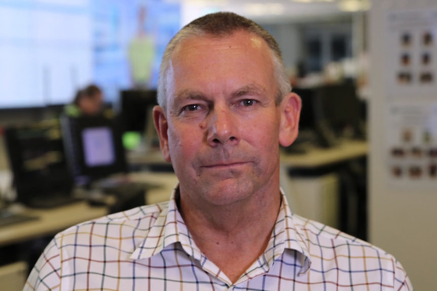 A mid-shot of DFES executive director rural fire Murray Carter posing for a photo in an office.