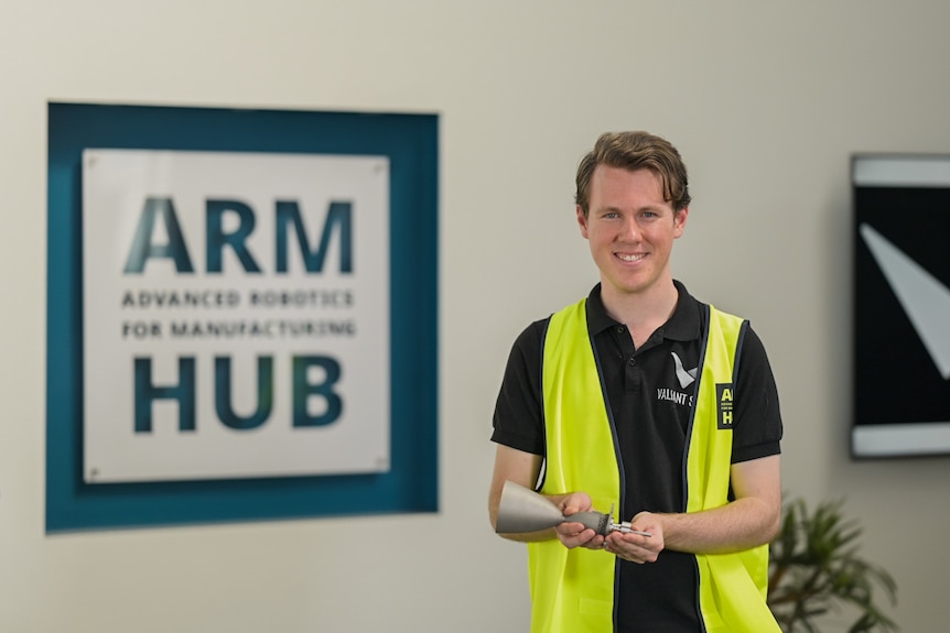 Andrew Uscinski holding the solenoid valve and thruster device. 