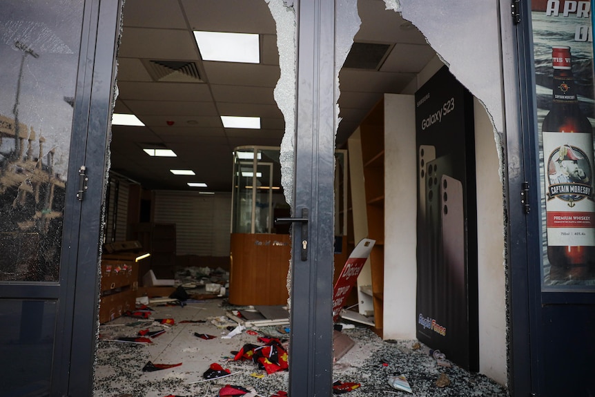 Modern secure glass doors of a shopfront are smashed and destroyed  