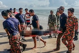 Emergency workers retrieve a victim of boat sinking