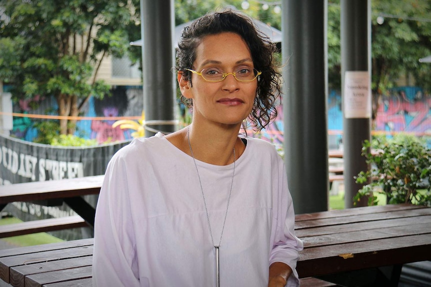 Seleneah More sits at a table in a park at West End in Brisbane.