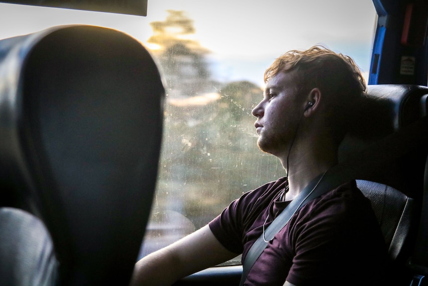 A young man falling asleep on a bus.