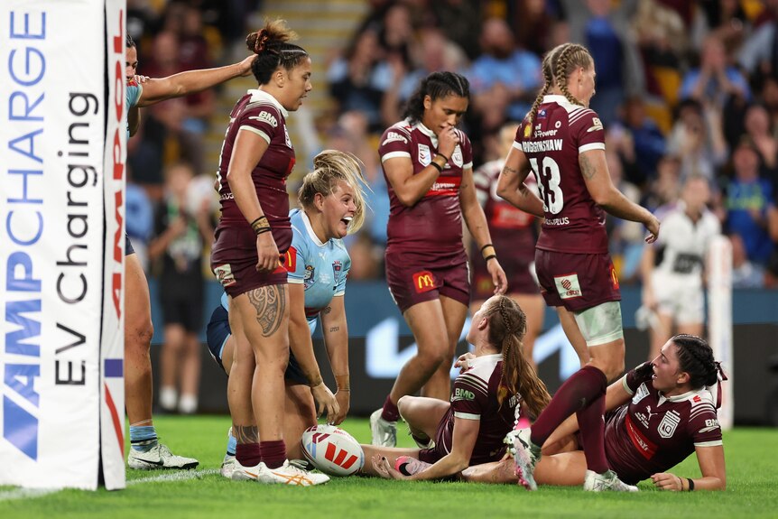 Caitlan Johnston celebrates a Women's State of Origin try as Queensland Maroons stand around her.