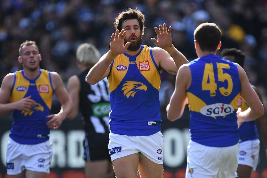 Josh Kennedy is congratulated after kicking a goal for the Eagles against the Magpies.