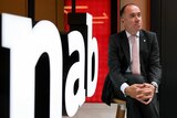 Andrew Thorburn poses for a photo in front on an NAB sign.