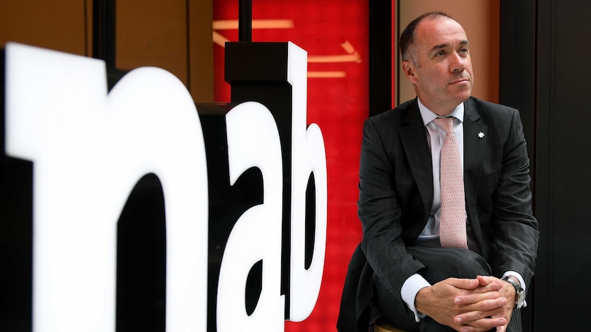 Andrew Thorburn poses for a photo in front on an NAB sign.