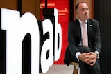 Andrew Thorburn poses for a photo in front on an NAB sign.