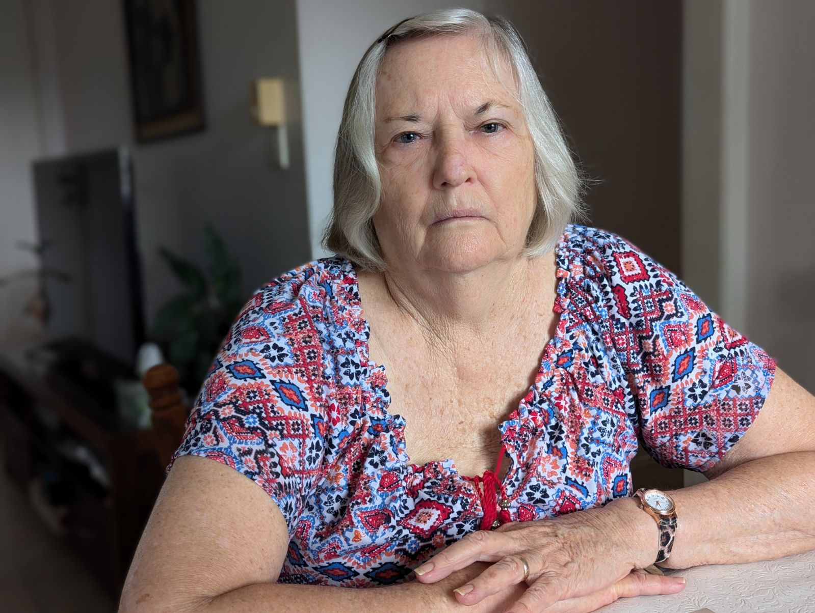 A serious-looking woman sitting at a table.