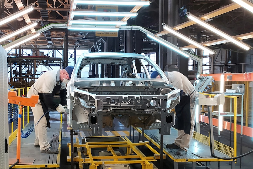 Los empleados trabajan en una línea de ensamblaje de automóviles.