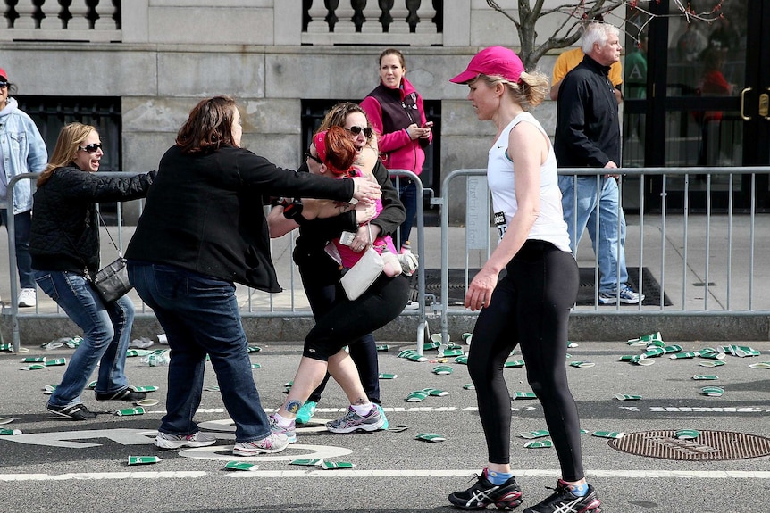 A runner embraces a woman after the Boston Marathon explosions.
