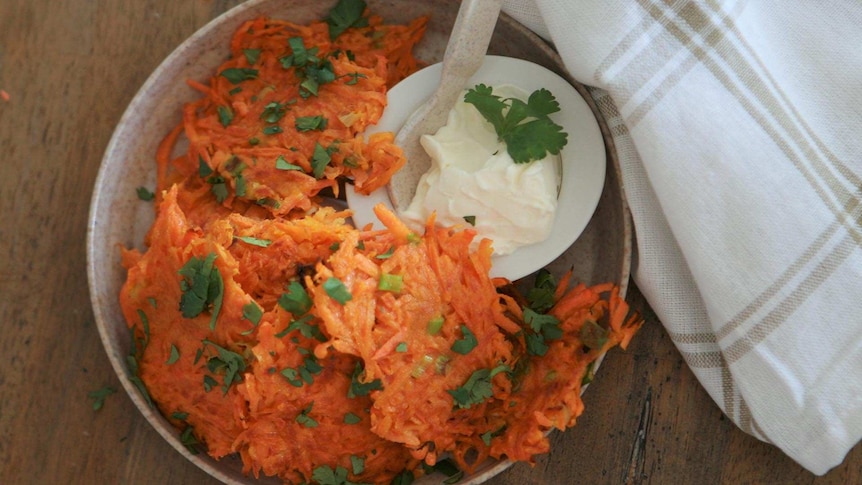 Sweet potato hash browns in a bowl and a bowl of sour cream