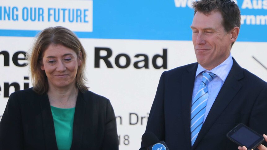 Rita Saffioti and Christian Porter laughing awkwardly in front of a government sign about a road project.