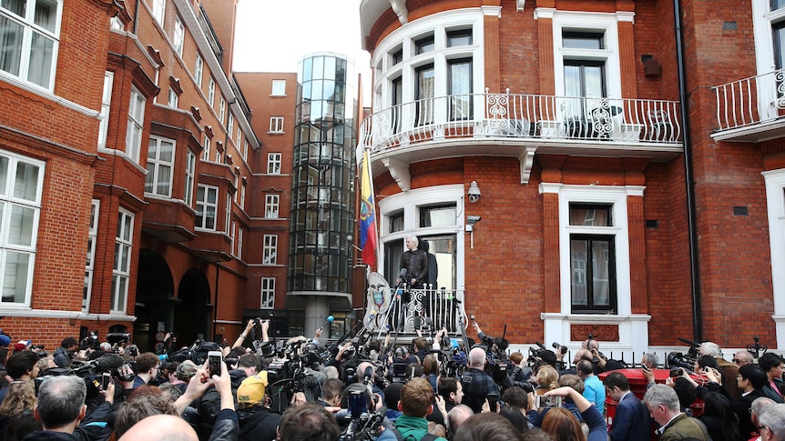 Julian Assange speaks to a crowd of people on the balcony of the Embassy of Ecuador in London.