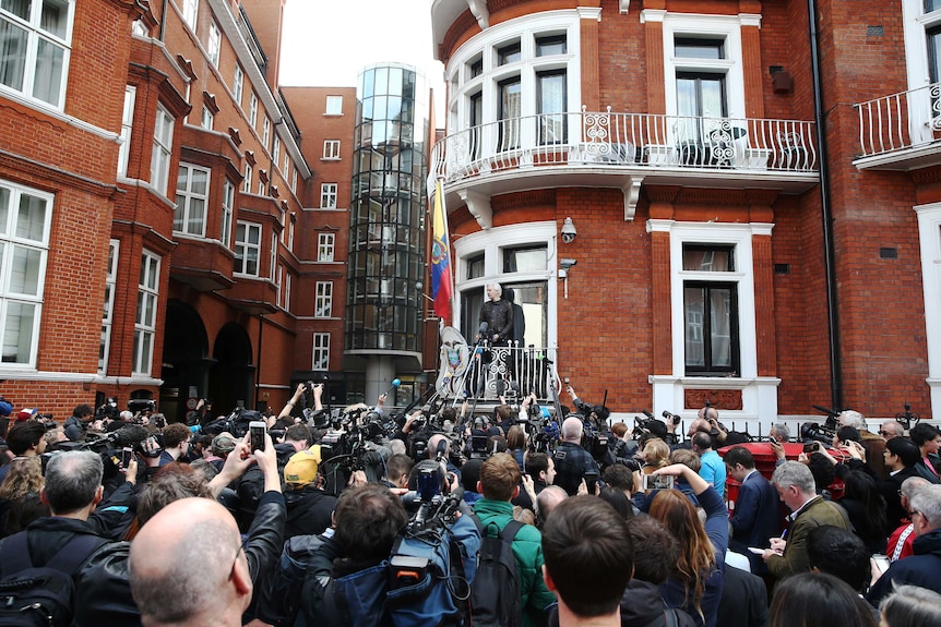 Julian Assange speaks to a crowd of people on the balcony of the Embassy of Ecuador in London.