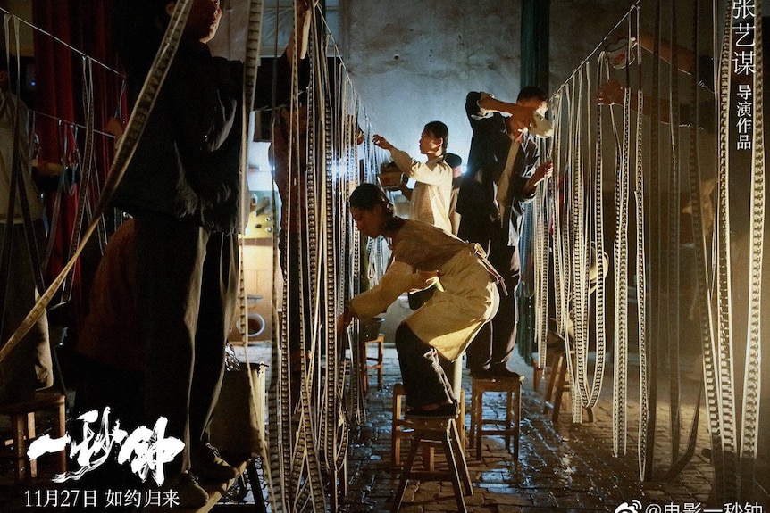 A movie scene showing a group of girls hanging film reels on railings.