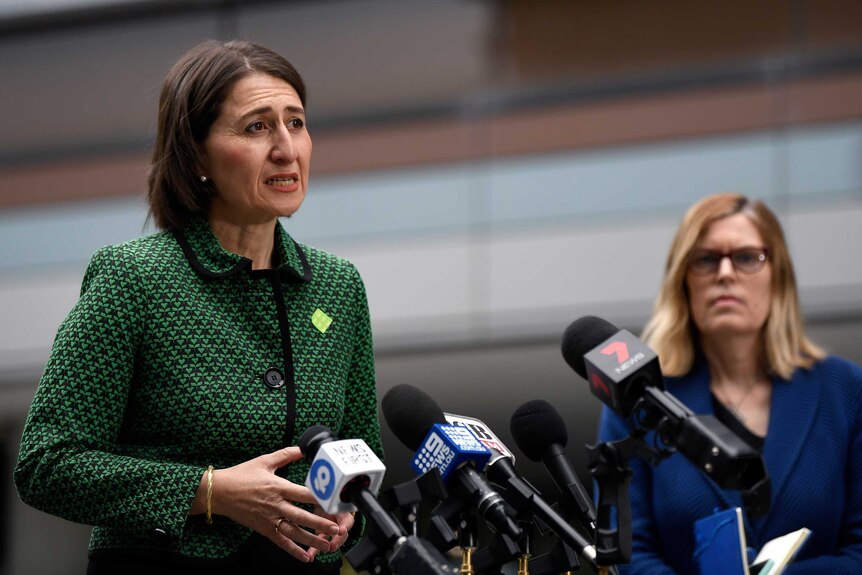 Gladys Berejiklian addresses the media as Dr Kerry Chant stands in the background.